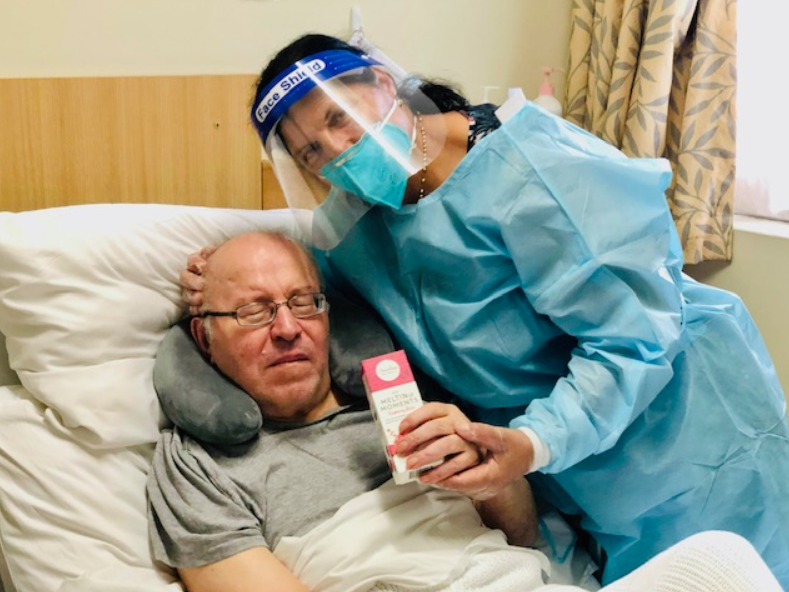 Mr Chamel and his wife from St Sergius holding the Valentine's Day gift in New South Wales. Mr Chamel's wife is in full protective gear with a mask, face shield and protective gown.